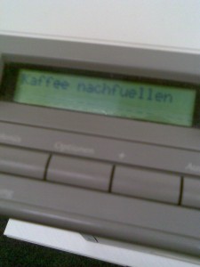 Foto eines HP-Laserdruckers mit dem Text "Kaffee nachfüllen" auf dem Display